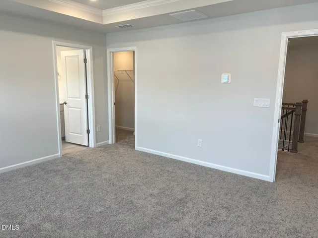 a view of an empty room with closet and a window