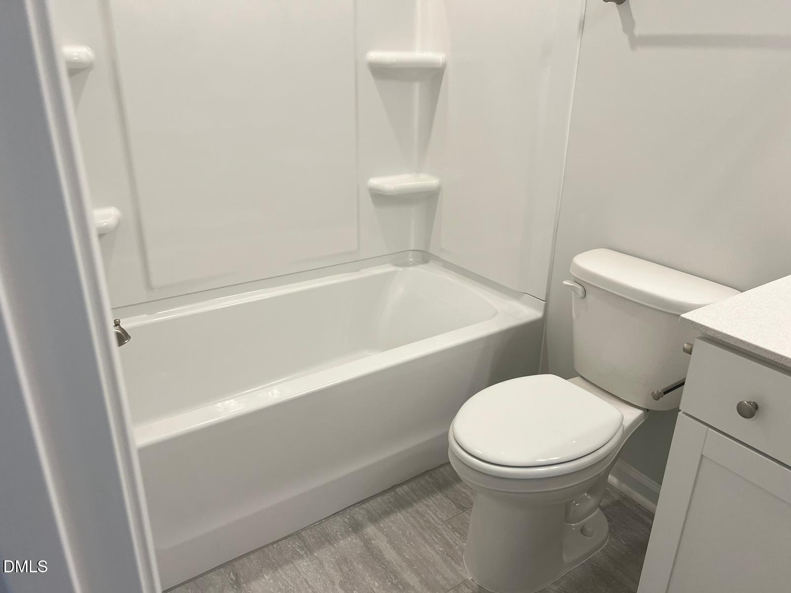 7226 Morris Acres Road Apex, NC 27523 - Photo 28 of 41 a white toilet sitting next to a bath tub