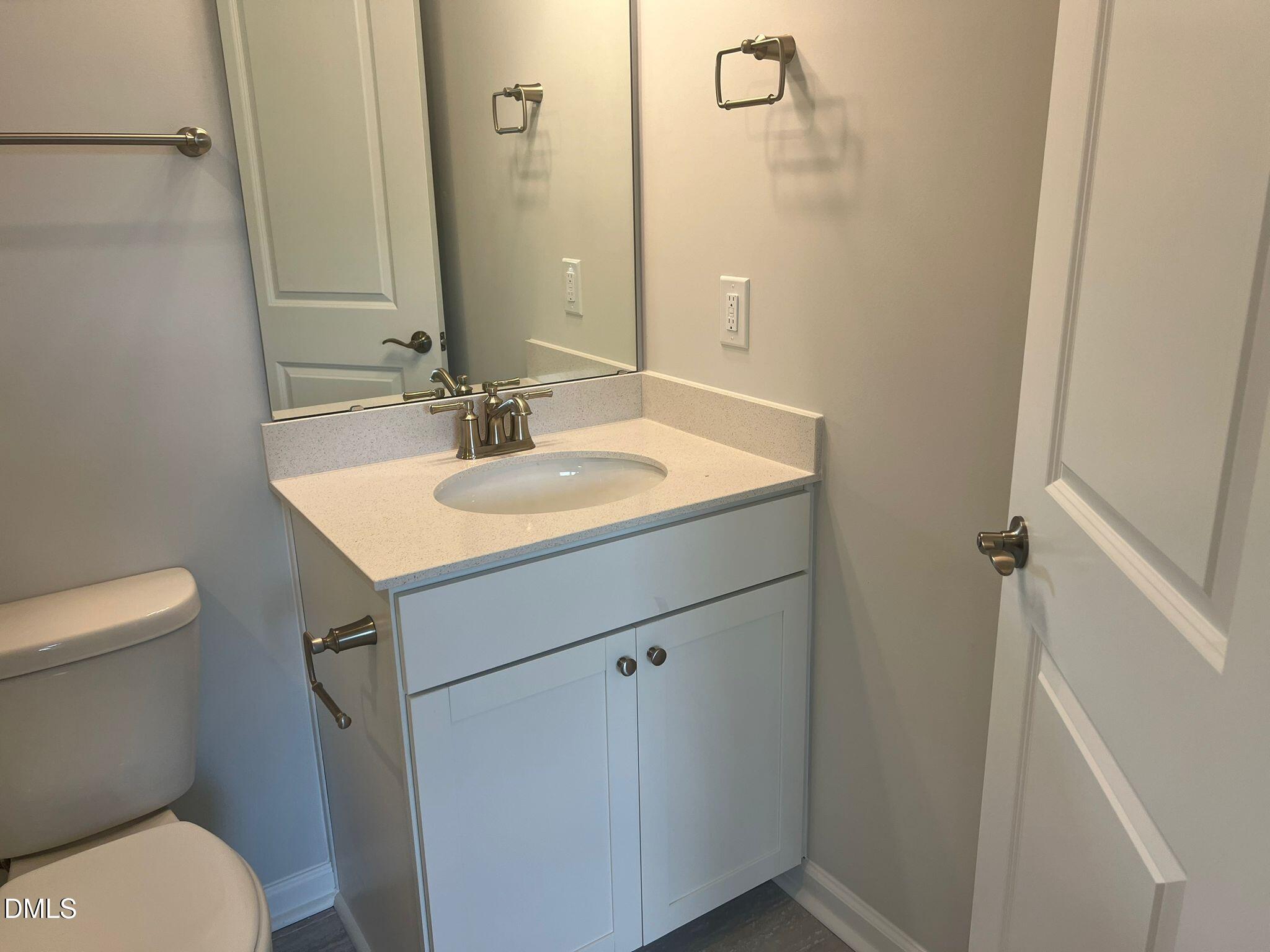 7226 Morris Acres Road Apex, NC 27523 - Photo 5 of 41 a bathroom with a toilet sink and mirror