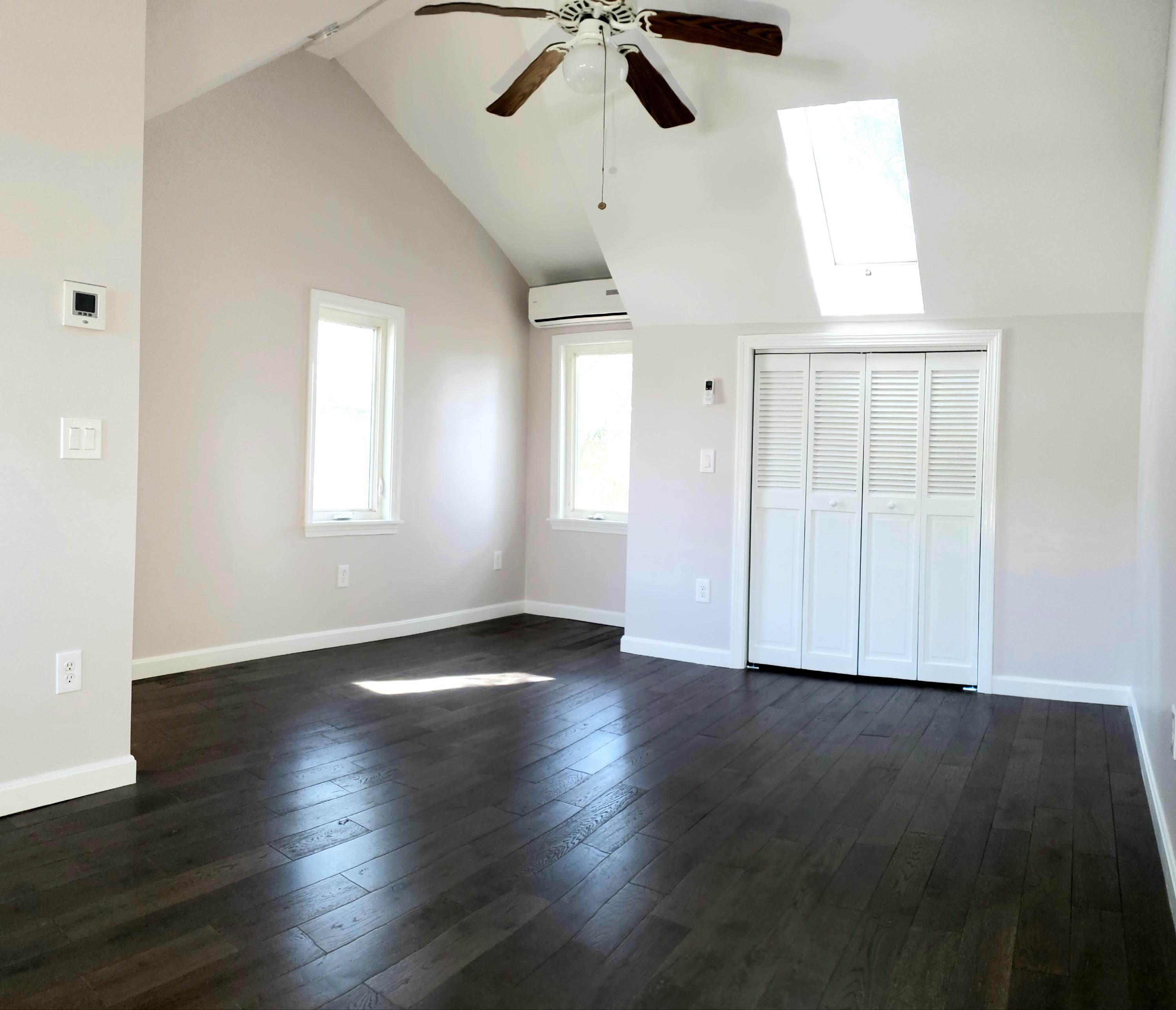9 Bells Neck Road, Unit 3 West Harwich, MA 02671 - Photo 18 of 23 an empty room with wooden floor chandelier fan and windows