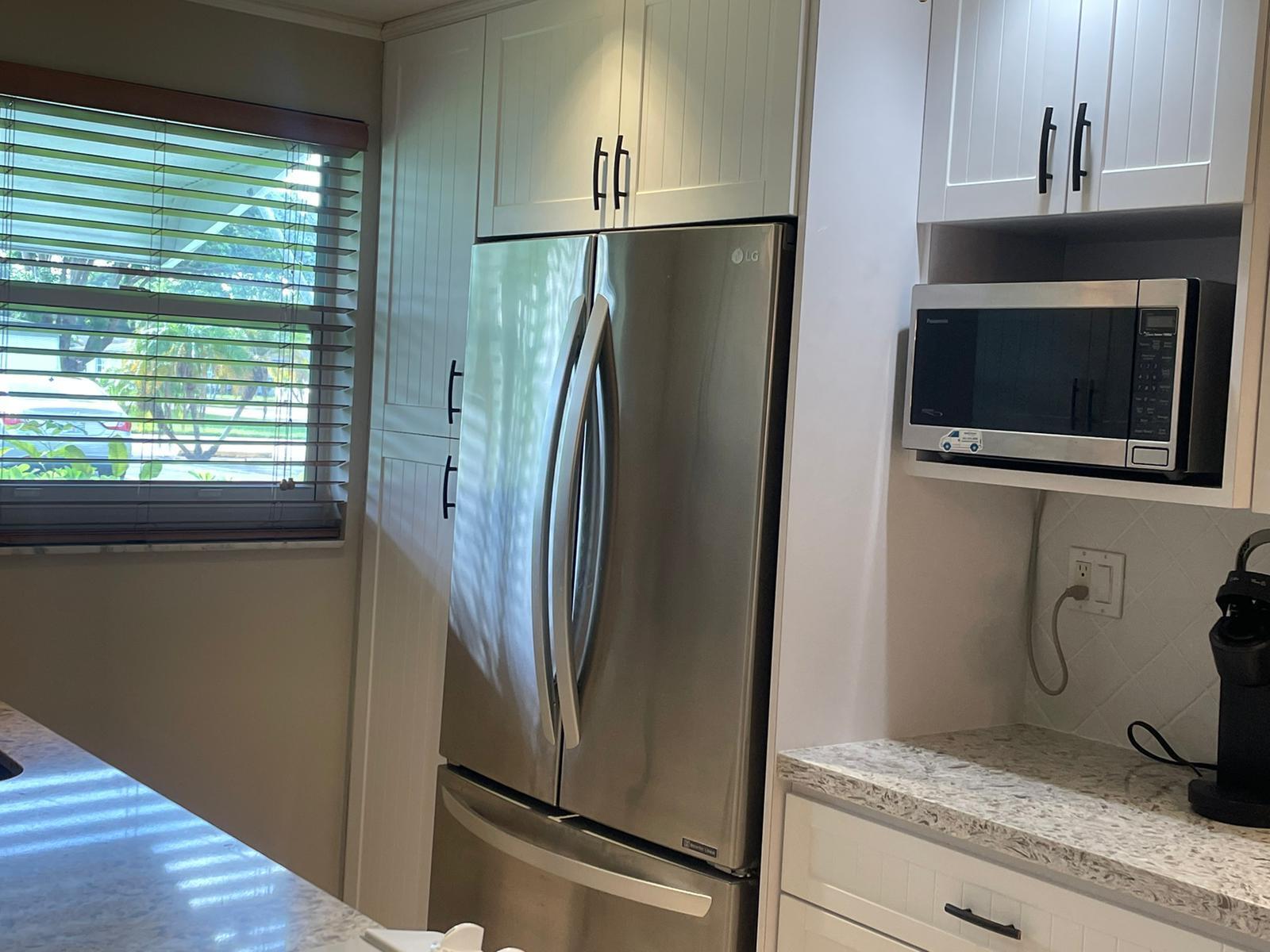 515 High Point, Unit C Delray Beach, FL 33445 - Photo 11 of 23 a view of a refrigerator in kitchen and an empty room