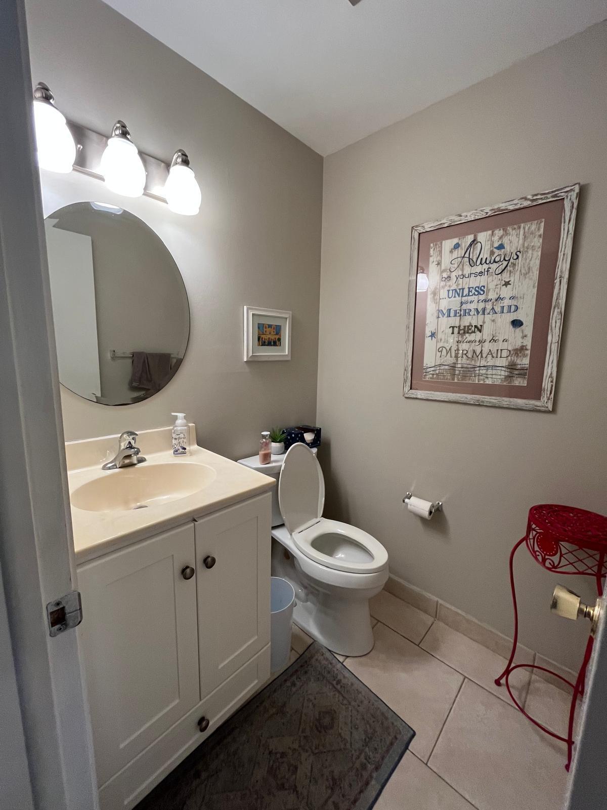 515 High Point, Unit C Delray Beach, FL 33445 - Photo 16 of 23 a bathroom with a toilet sink and mirror