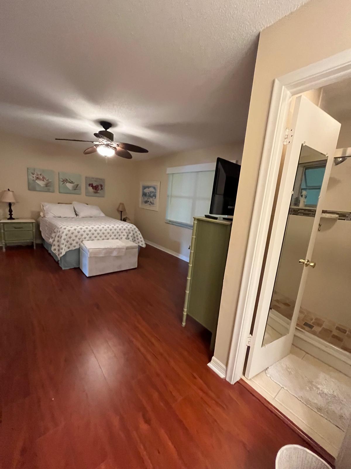 515 High Point, Unit C Delray Beach, FL 33445 - Photo 18 of 23 a spacious bedroom with a bed and a mirror on the dresser
