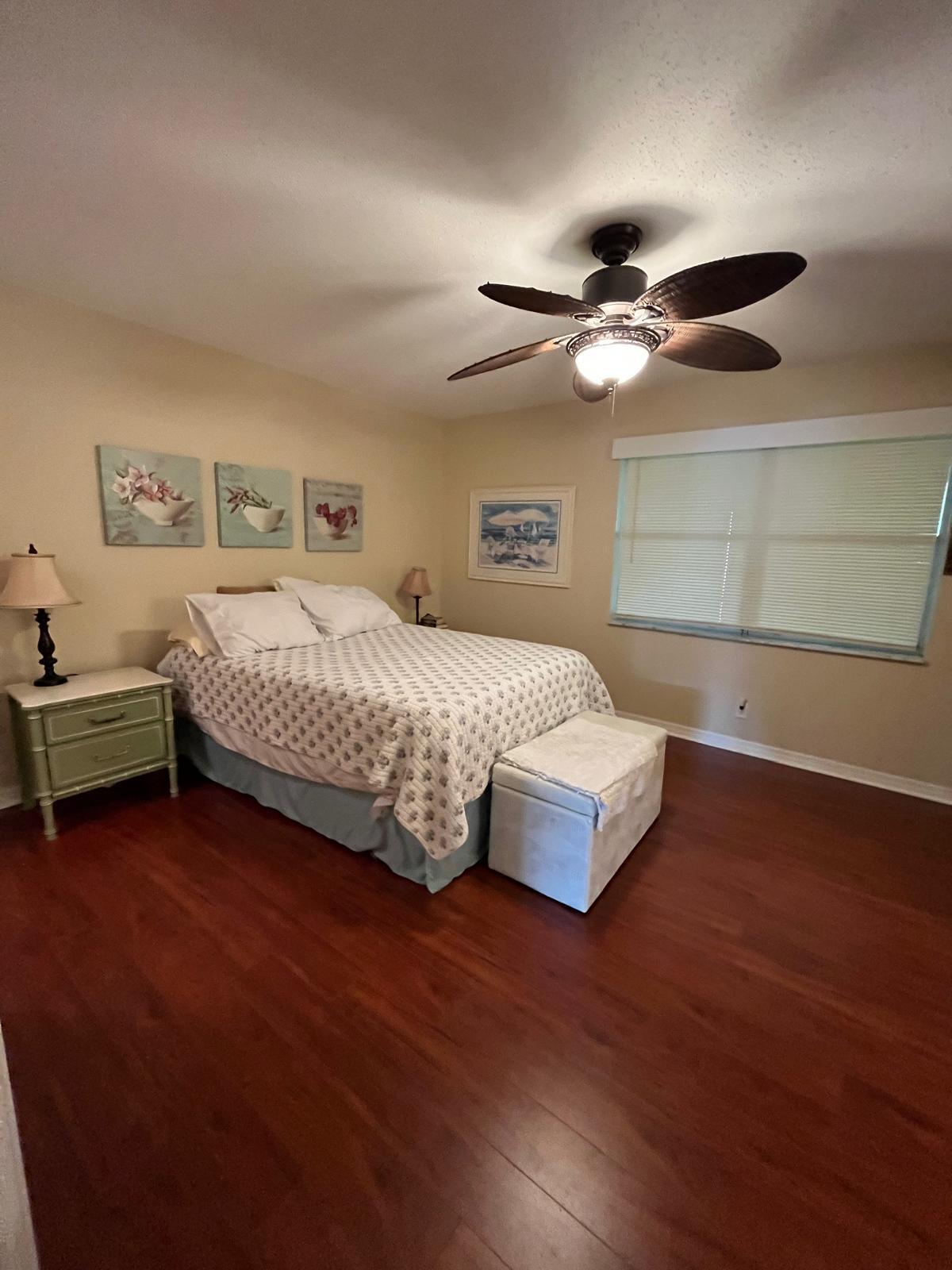 515 High Point, Unit C Delray Beach, FL 33445 - Photo 19 of 23 a bedroom with a bed chandelier and a window