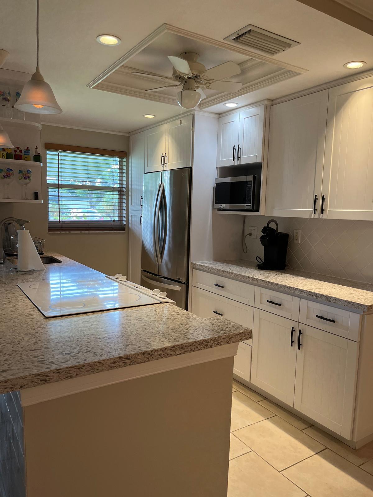 515 High Point, Unit C Delray Beach, FL 33445 - Photo 9 of 23 a kitchen with stainless steel appliances granite countertop a sink a stove top oven a counter space and cabinets