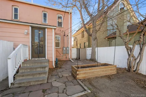 a backyard of a house with barbeque oven table and chairs