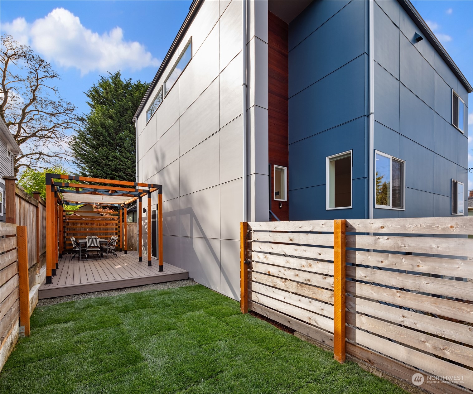 a view of a back yard of the house with a bench