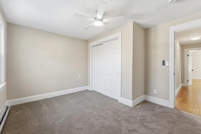 an empty room with a ceiling fan and a window