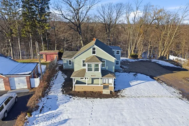 a front view of house with yard and trees in the background