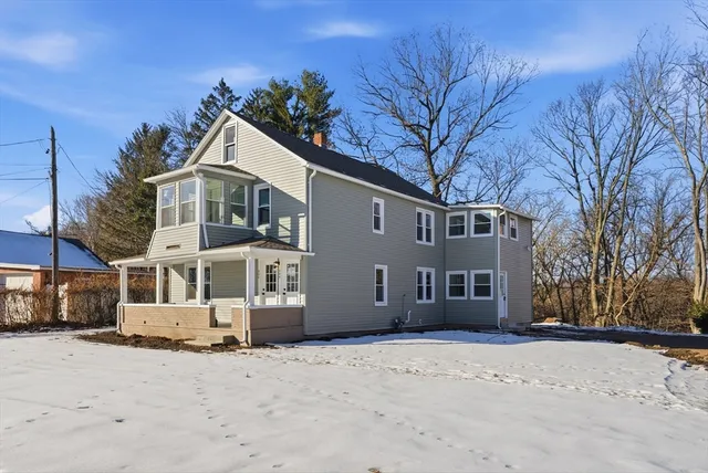 a front view of a house with a yard covered in snow