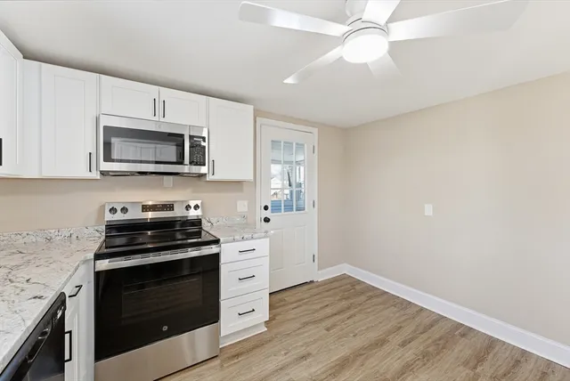 a kitchen with granite countertop a stove a microwave and cabinets