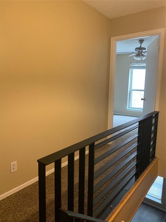 3121 Rosedale Avenue University Park, TX 75205 - Photo 11 of 16 Upper-level hallway featuring a modern black metal horizontal stair railing and neutral-toned carpeting