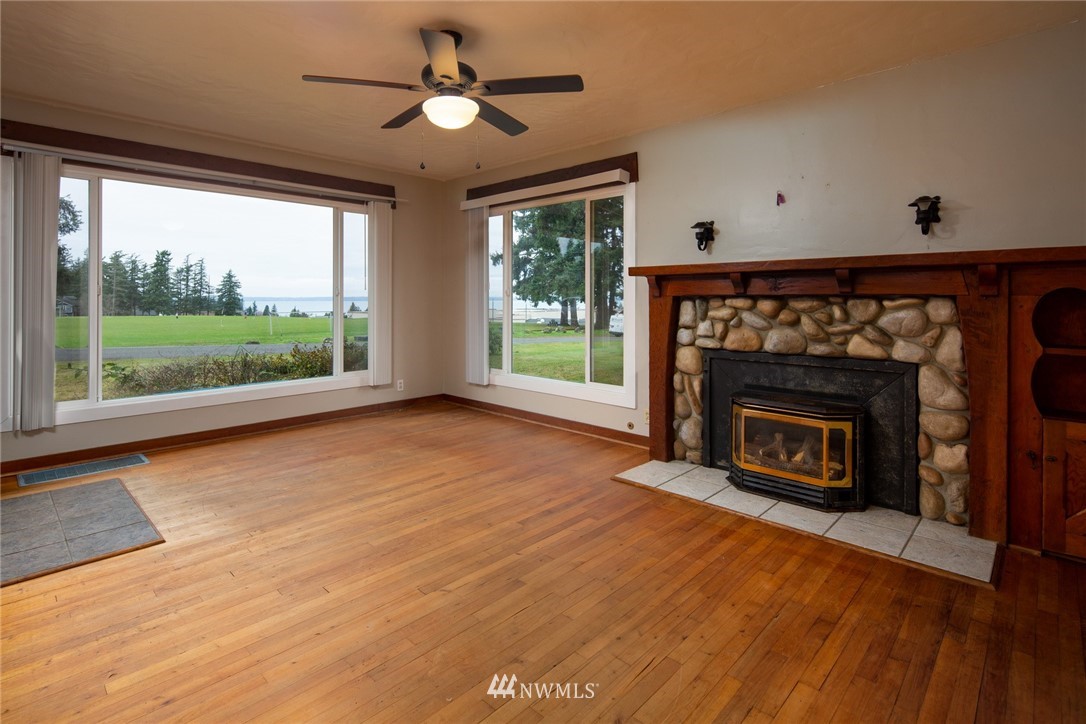 209 Parkridge Road Bellingham, WA 98225 - Photo 6 of 33 a view of an empty room with wooden floor fireplace and a window