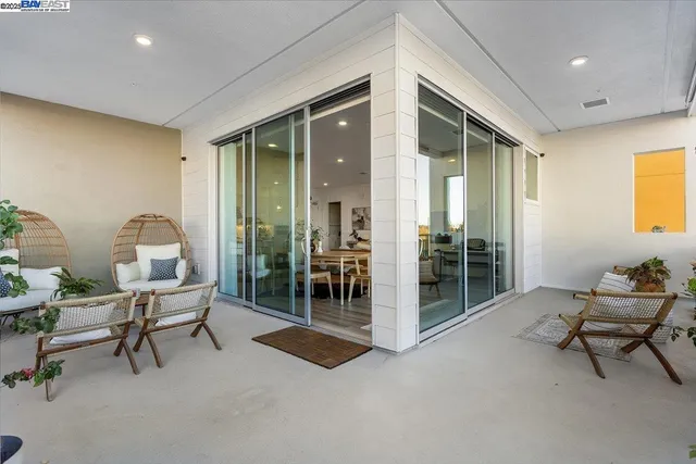 a view of a balcony with chairs and potted plants