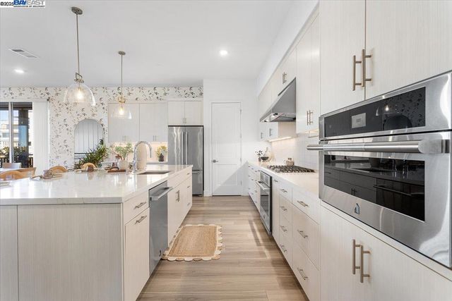 a kitchen with appliances cabinets and a stove top oven