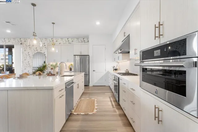 a kitchen with appliances cabinets and a stove top oven
