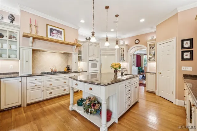 a kitchen with stainless steel appliances granite countertop a sink a oven and wooden floors