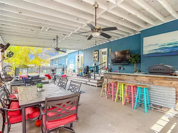 a living room with furniture kitchen view and a large window