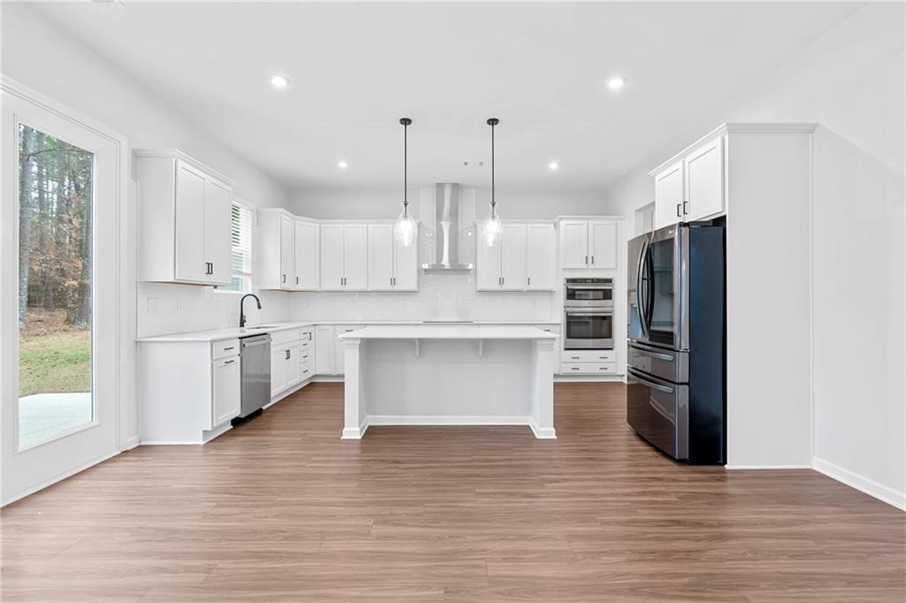 3699 Annsbury Court Lilburn, GA 30047 - Photo 13 of 45 a large kitchen with stainless steel appliances kitchen island a large counter top and a refrigerator