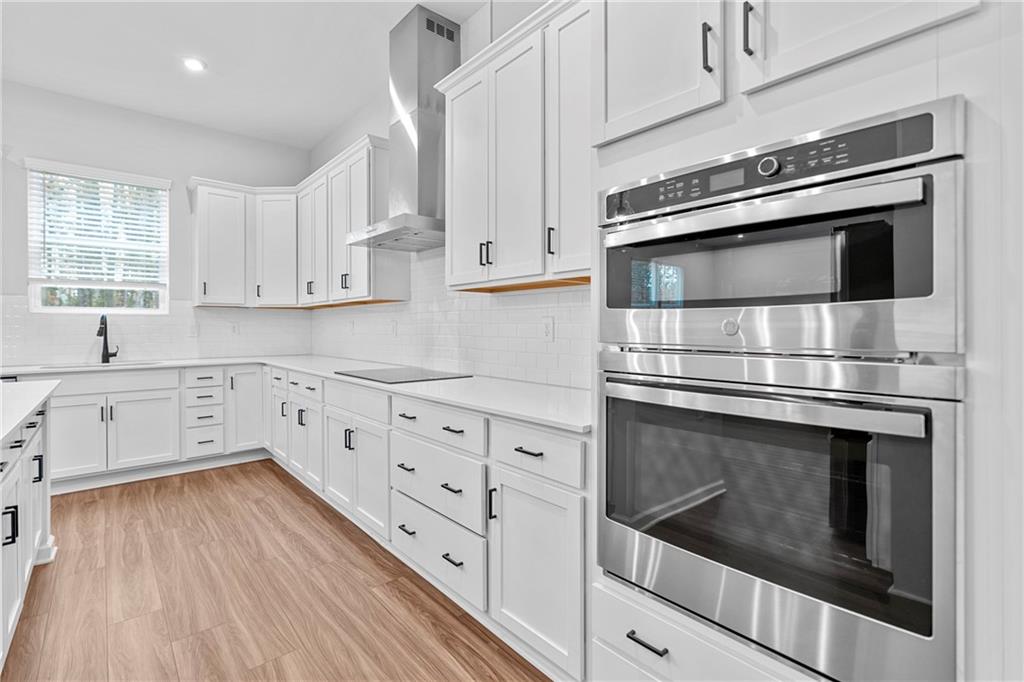 3699 Annsbury Court Lilburn, GA 30047 - Photo 16 of 45 a kitchen with granite countertop white cabinets stainless steel appliances and wooden floor