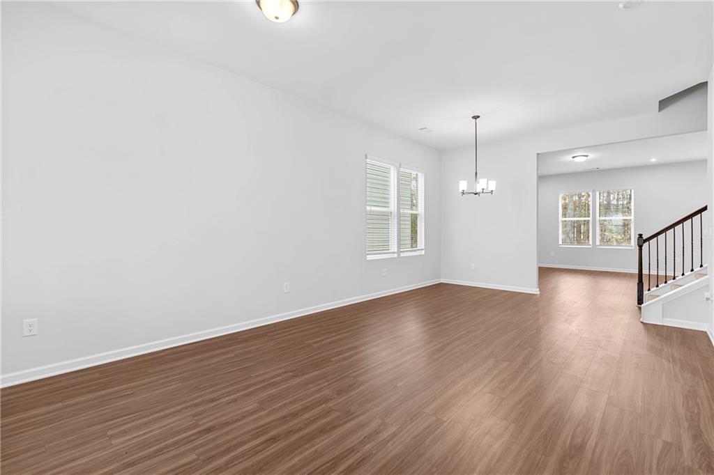 3699 Annsbury Court Lilburn, GA 30047 - Photo 6 of 45 an empty room with wooden floor and windows