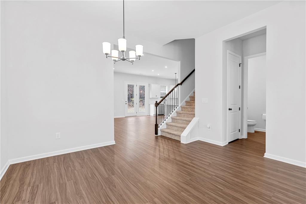 3699 Annsbury Court Lilburn, GA 30047 - Photo 7 of 45 a view of an empty room with wooden floor and a chandelier