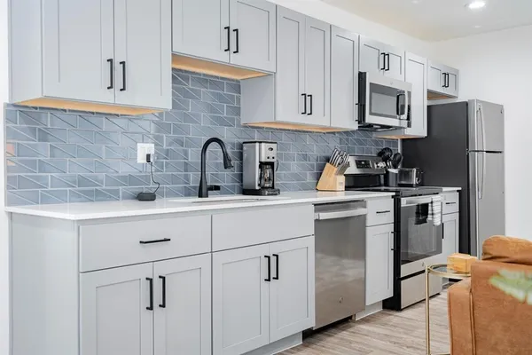 a kitchen with white cabinets stainless steel appliances and sink