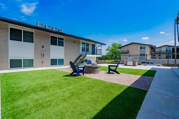 a view of a backyard with table and chairs under an umbrella