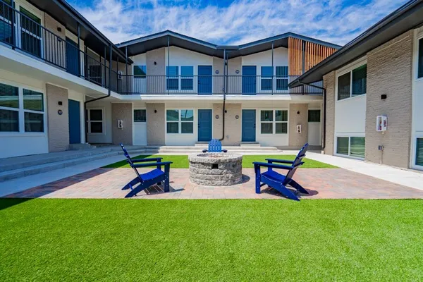 a view of a house with a yard fire pit and outdoor seating