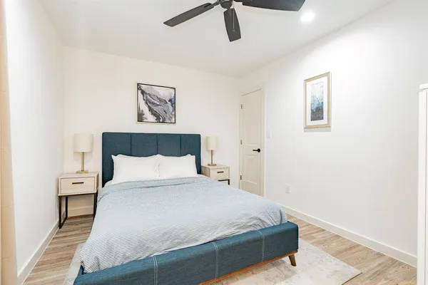 a bedroom with a bed and painting on the wall