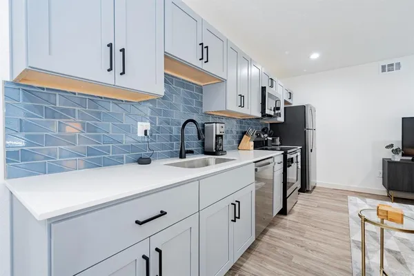 a kitchen with a sink appliances and cabinets