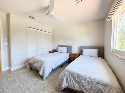 a bedroom with two beds and a window