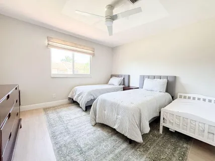 a bedroom with two beds and a window