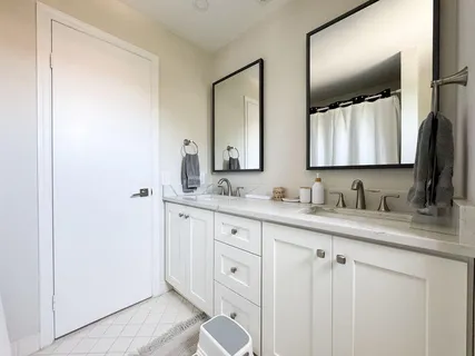 a bathroom with double sink and a mirror