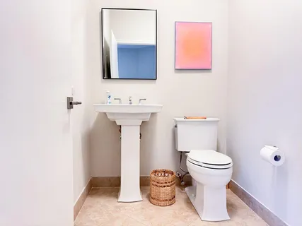 a bathroom with a toilet sink and mirror