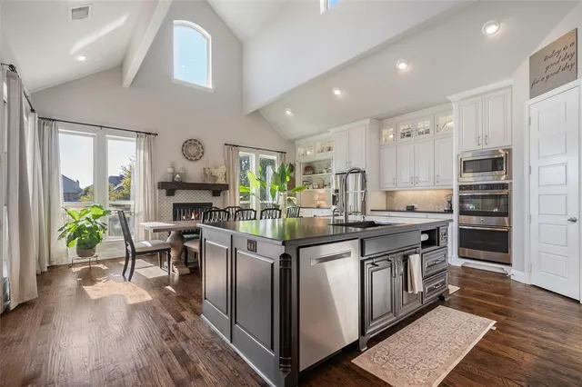 a kitchen with stainless steel appliances granite countertop a stove and a wooden floors