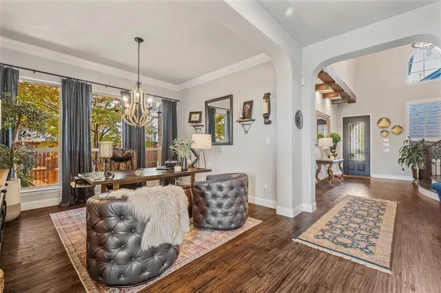 a living room with furniture large window and wooden floor