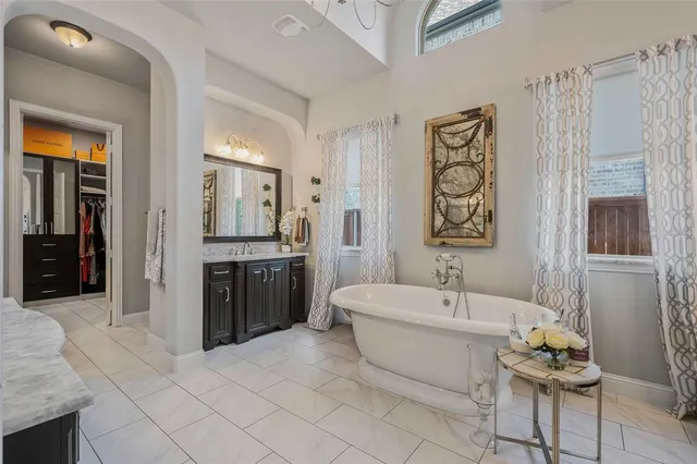 a spacious bathroom with a double vanity sink a mirror a bathtub and shower