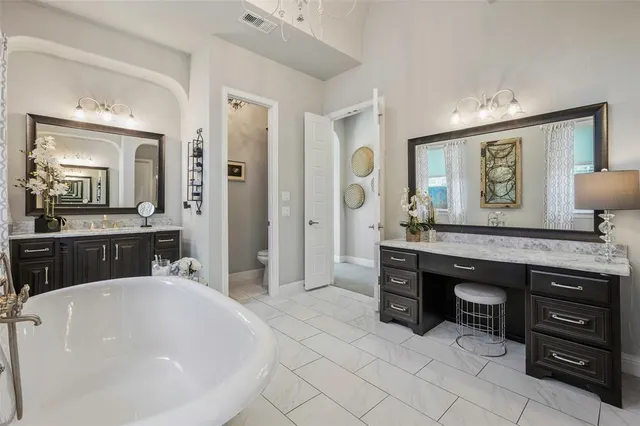 a en suite bathroom with a granite countertop sink and a mirror