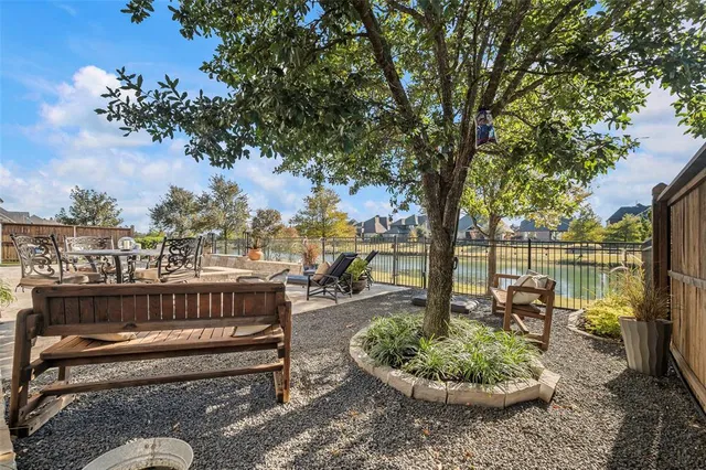 a view of a garden with lawn chairs and a fire pit