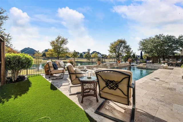a view of a swimming pool with outdoor seating and plants