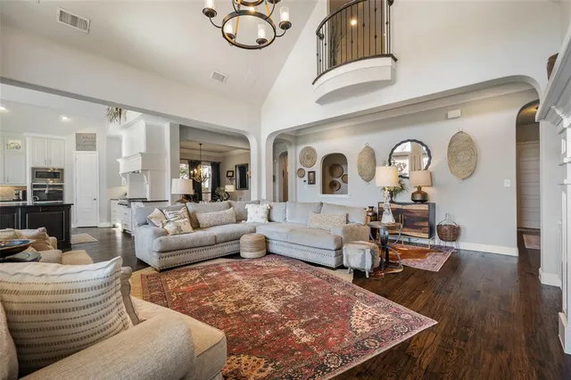 a living room with furniture kitchen view and a wooden floor