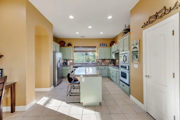 a kitchen with stainless steel appliances granite countertop a sink and a refrigerator