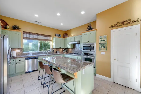 a kitchen with stainless steel appliances granite countertop a refrigerator and a sink