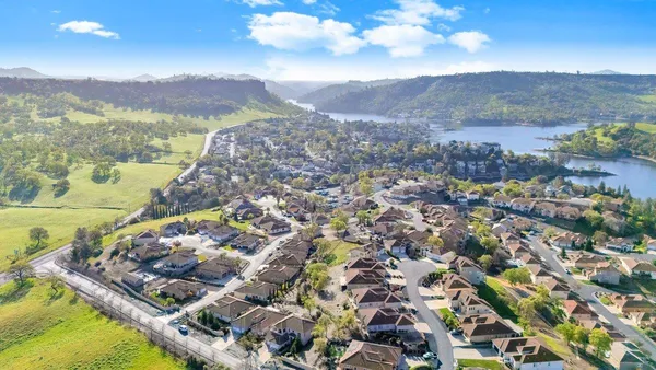 an aerial view of ocean and residential houses with outdoor space