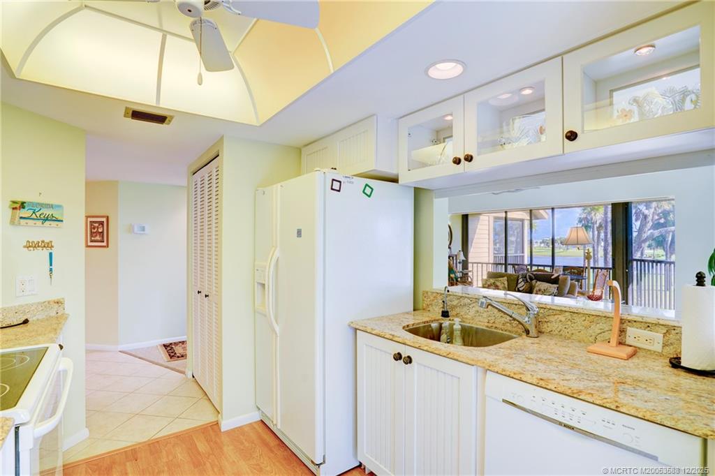 233 Northeast Edgewater Drive, Unit 204 Stuart, FL 34996 - Photo 16 of 56 a kitchen with a sink a counter top space and living room view
