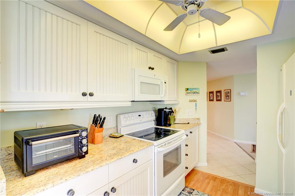 233 Northeast Edgewater Drive, Unit 204 Stuart, FL 34996 - Photo 17 of 56 a kitchen with stainless steel appliances granite countertop a sink a stove and a refrigerator