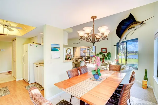 a dining room with wooden floor a chandelier a wooden table and chairs