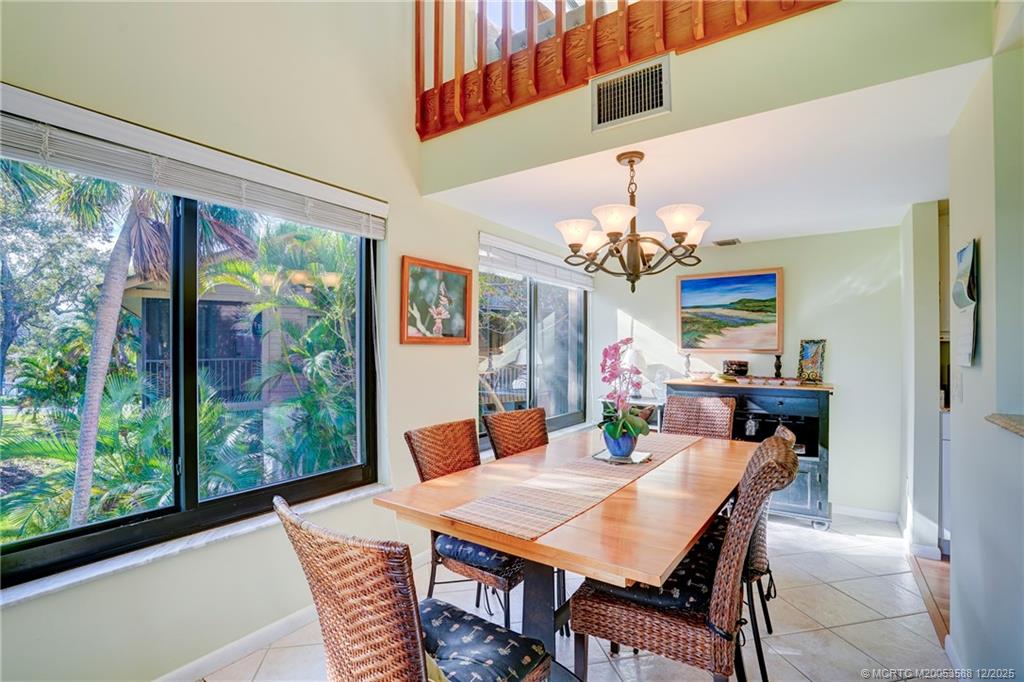 233 Northeast Edgewater Drive, Unit 204 Stuart, FL 34996 - Photo 20 of 56 a view of a dining room with furniture a chandelier and large windows