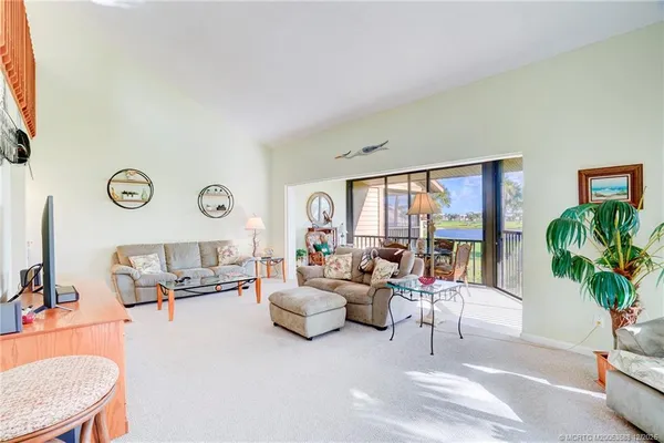 a living room with furniture a fireplace and a large window